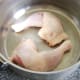 Whole chicken legs are laid in base of soup or stock pot