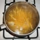 While meat mixture is simmering, bring 6 cups of water to a boil. Add spaghetti or angel hair pasta to boiling water.