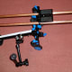 Shoulder Rig with camera plate on top of parallel supports, hand grips below, and articulating magic arm and support clamp.