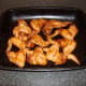 Chicken wings are laid on a roasting tray for the oven