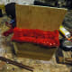 Upholstery material tacked into place with upholstery nails and backing glued in place