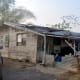 With many roof leaks and weak walls, this could barely be called a house. See the people in the background surveying for a possible building site.