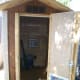 Close up of front with door open. Corner trim still unvarnished. T1-11 was stained before applying varnish.