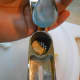 A garlic clove in the bottom of a garlic press.