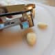 Get ready to put each clove into your garlic press.
