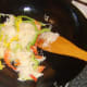 Sliced bell peppers are added to rice noodles