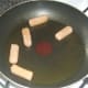 Gently frying mini sausages