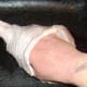 Roasting rub is carefully inserted under the skin of the turkey drumstick