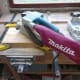 Use a belt sander to smooth the wooden shelf supports to a uniform width.