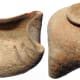 Indus Valley, Nal Culture of Baluchistan, 2900 - 2500 BC. The terracotta oil lamp. The body rounded with raised disk foot, the corners pinched to form spouts, brown line decoration on each. Intact with earthen encrustation