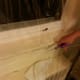 Apply shrink wrap to the window along the path of the adhesive tape, leaving about five inches of overhang. Then cut off the overhang.
