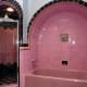 pink bathroom with vintage tile in pink and black with arch around bathtub enclosure