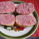 Half bread rolls with raw minced pork with salt and pepper.