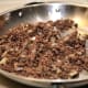 When meat is browned, add seasonings and flour. Mixture will absorb the flour and be a little stickier.