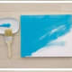 Step 2: Apply a different base coat of paint with the chip brush to each of the stretched canvases, including the edges.