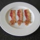 Preparing to wrap cocktail sausages in bacon