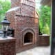 brick fireplace appearing massive in scale complete with brick pedestals holding lanterns