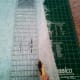 Removing the loose fringe while straightening the fabric's edge.