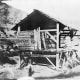 "Photomechanical reproduction of the 1850 daguerreotype shows James Marshall standing in front of Sutter's sawmill, Coloma, California, where he discovered gold." Person depicted is most likely not actually Marshall.