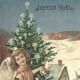 Vintage angel with Christmas tree and snow-covered town in the background