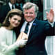 Jackie Kennedy wearing gloves standing next to Ted Kennedy waving