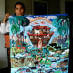 An arpillerista proudly displays her large arpillera of Noah's ark.