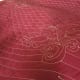 This red whole cloth quilt has been quilted by machine.