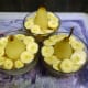 Placing the pears in the dessert dish, on top of the yogurt and then adding raspberries and sliced bananas around the sides.