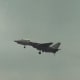An F-14 with its wings extended and its landing gear down.