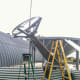 The first sheet is bolted in place. The weather must be calm, as a roof at the beginning stages is fragile.