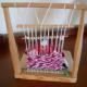 View through the loom at a woman weaving