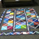 This unfinished quilt uses a combination of batik fabrics with a solid white fabric.