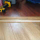 Step up into home office with laminated wood floor using scrap wood to make door step.