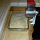 This shows you the side view of the grinder. It comes with a pusher to protect your fingers as you push the nuts down into the hopper. Do not immerse this pusher. It is hollow and the water goes inside and is hard to remove. Just rinse and dry.