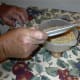 Here Kosta is emptying a freshly inspected plate of wheat into the bowl.