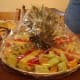 Lay out the pineapple top and the prepared pieces around it.