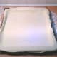 Brush the baking dish with lard and lay the pastry gentle in the dish,stretching it, with hands, up the sides and to the edge of the baking dish, over the edge.