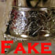 Base has messy, poorly defined decoration. Silver is flaky, and bubbly. Both are signs of reproduction fakes. the silver is also overly bright.