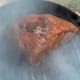 Pork cooking on top of beef brisket.