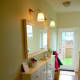 Remove the back legs to bring the cabinet closer to the wall. Add a mirror and overhead lighting to make the room look larger.