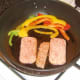 Spam slices are fried with bell peppers