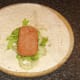 Spam slice tops cabbage and onion on tortilla wrap