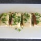 Coriander garnish is scattered on cheese and Spam finger bites