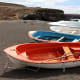 Red, blue and white rowing boats on the black sand beach of Ajuy on the western coast of Fuerteventura, a small village which is also shown elsewhere on this page