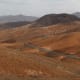 In south central Fuerteventura, the distinctive reddish landscape comprises low undulating hills for as far as the eye can see