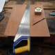 Using a handsaw to cut the facing plate for the rear left speaker