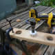 Cutting access points, with a large hole saw, in the two large pieces of recycled wood being used to make teh cable management trough
