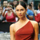Megan Fox in a revealing dress with a hip high slit up the side wearing platform high heels