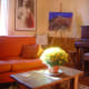 There is a piano in the sunny sitting room