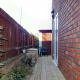 Wooden recycle bin on left, just outside the kitchen back door.